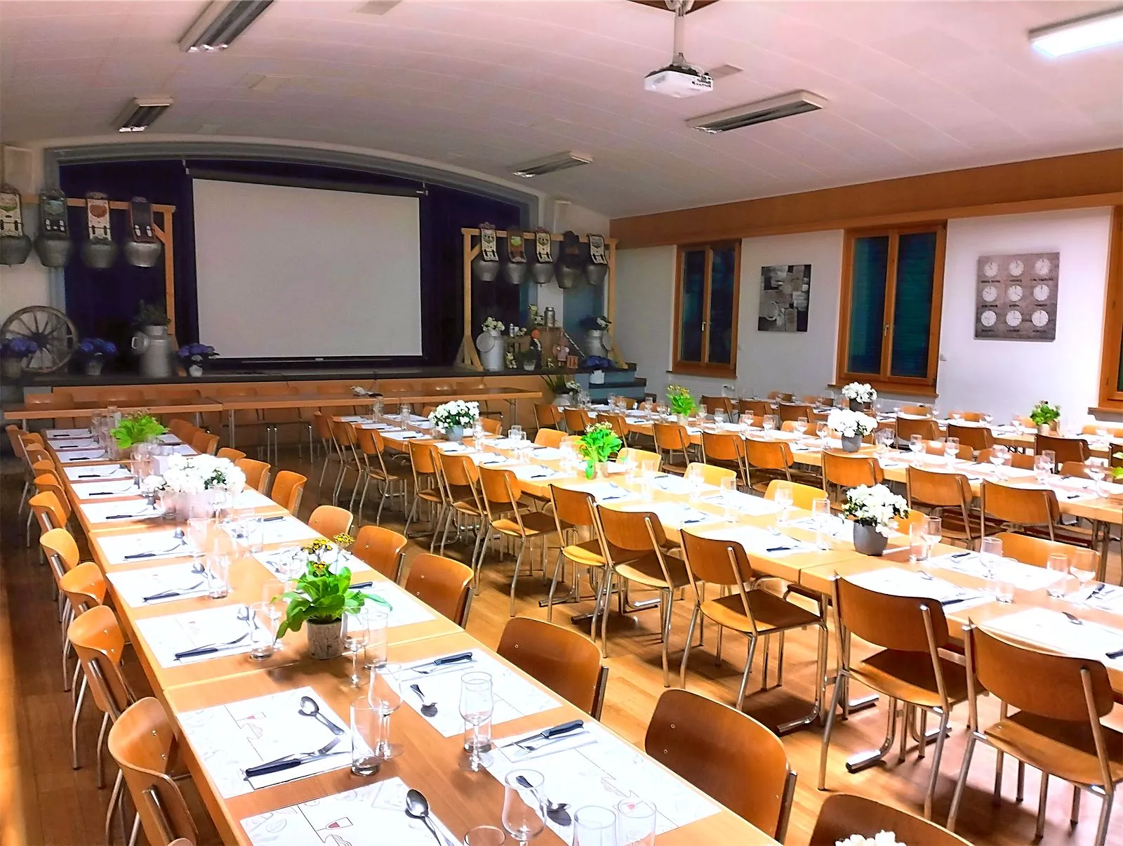 La Grande Salle de La Croix Fédérale dressée pour un banquet, avec scène et grand écran